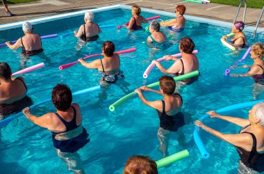 Aquafitnessteilnehmer mit Aquanoodle im Wasser