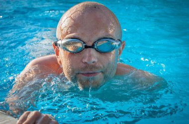 Mann am Beckenrand mit Schwimmbrille